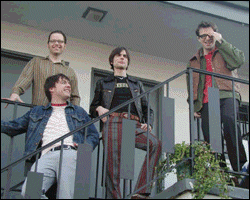 weezer on a balcony somewhere. those are some sick-ass pants, brian. l to r: mikey, pat, brian, rivers.